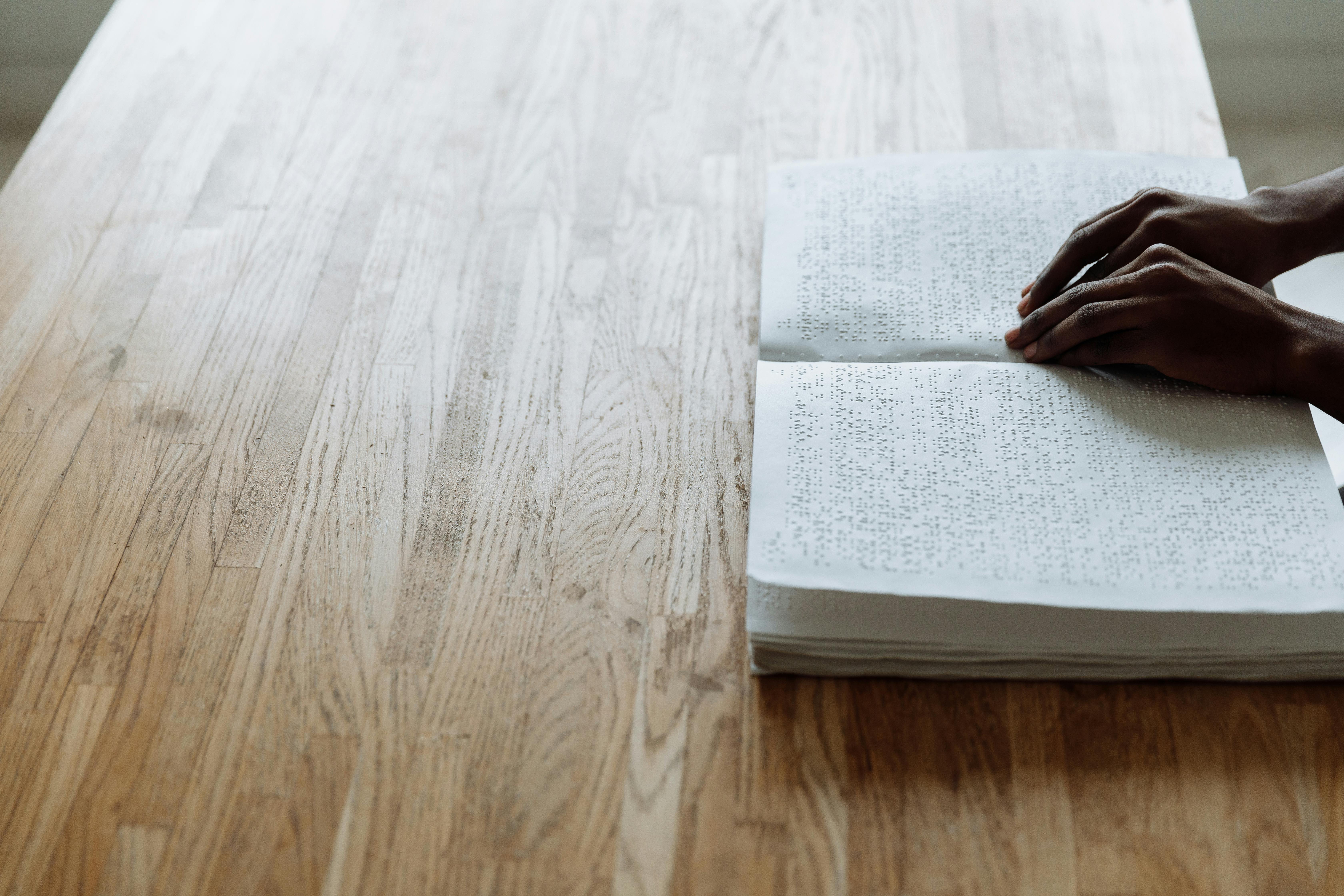 person in black leather shoes on white book page