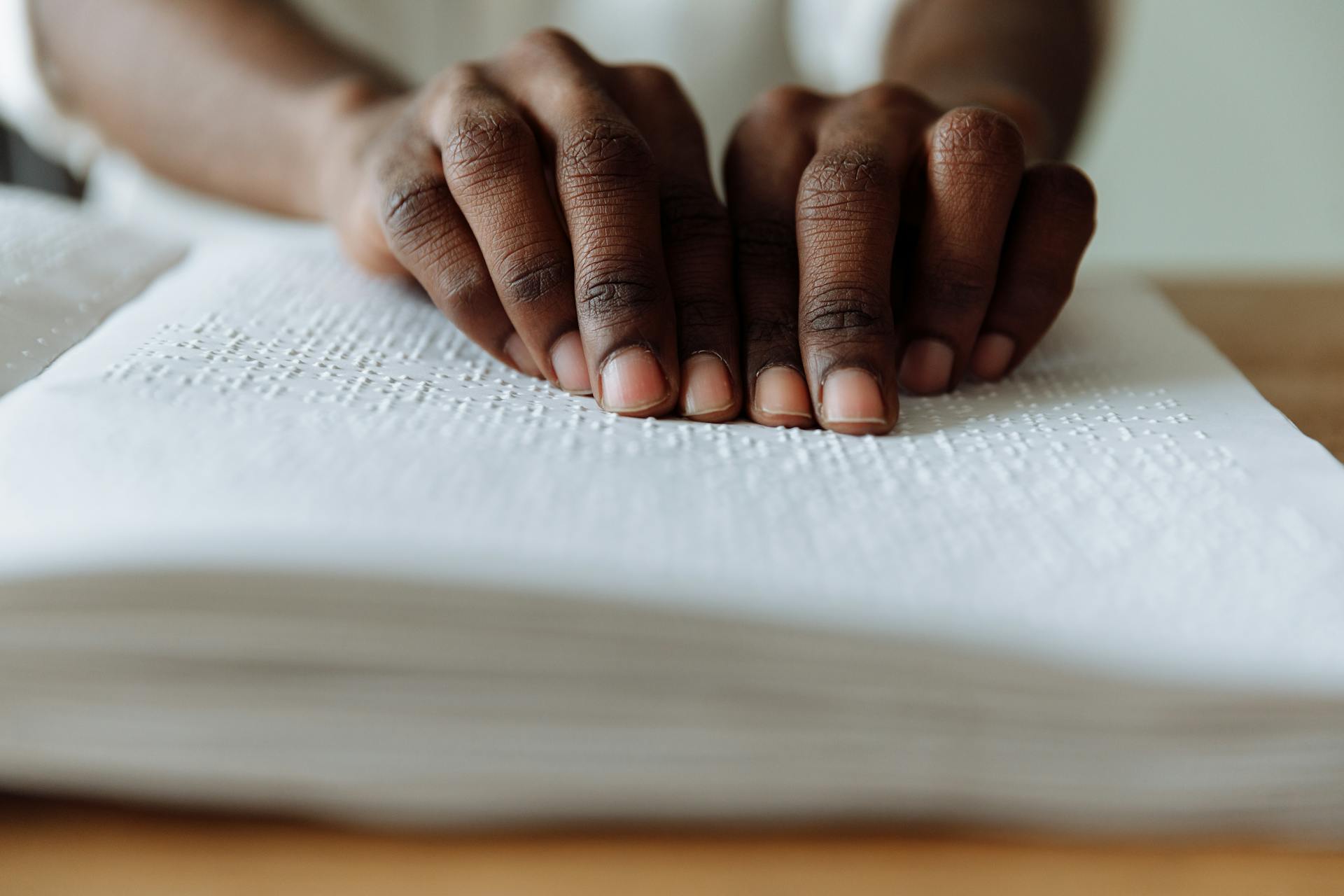 Close-up of hands reading Braille, highlighting sensory skill and independence.