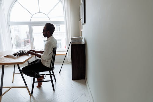 Man in White Dress Shirt Sitting on Chair