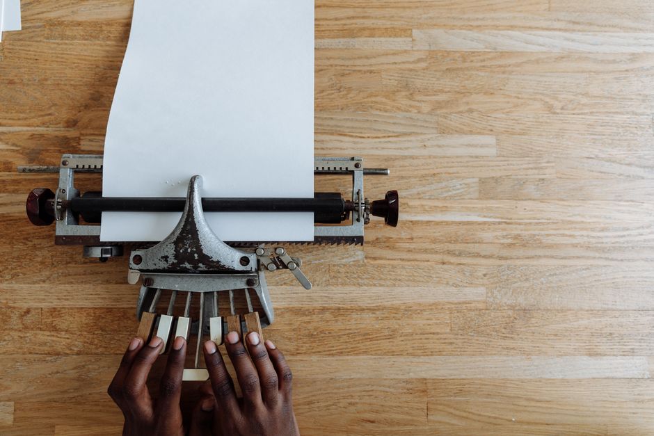 Close-up of hands typing on a braille typewriter for visual impairment on a wooden table. Close-up of hands typing on a braille typewriter for visual impairment on a wooden table.