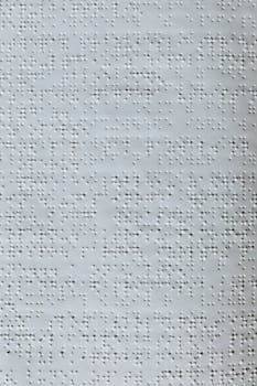 Detailed close-up image of Braille text embossed on paper, highlighting assistive technology.