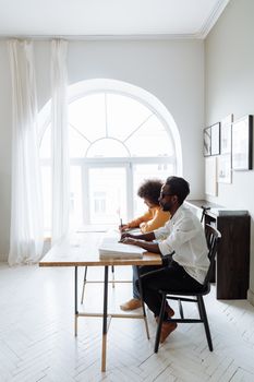 A mentor and student work together at a table in a bright, modern room.
