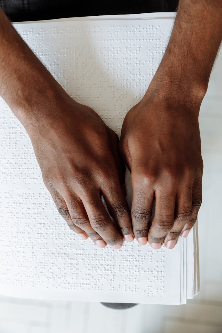 Hands Touching A Braille Paper 