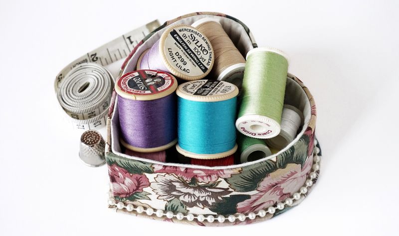 Neatly arranged craft and sewing supplies in a small workspace showing organized storage