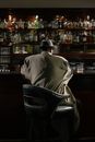 Photo of Person Sitting in Front of Bar Counter