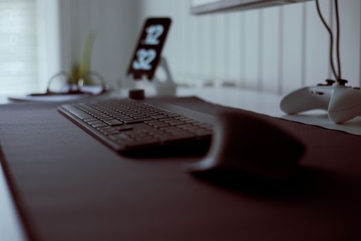 A stylish home office setup featuring a sleek keyboard and gaming controller.