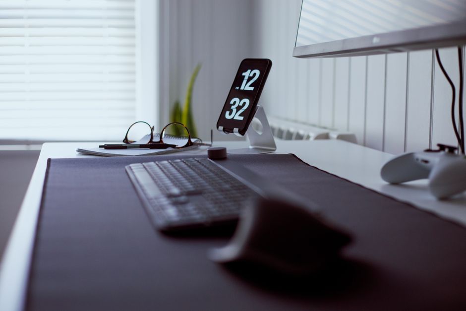 A sleek and modern workspace featuring a keyboard, tablet, and gaming controller with a minimalistic design.
