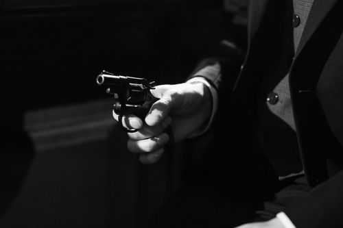 Free Black and white image capturing a suspenseful noir scene with a handgun. Stock Photo