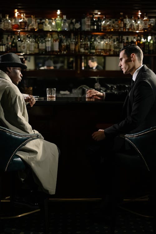 Photo of Men Sitting in Front of Bar Counter