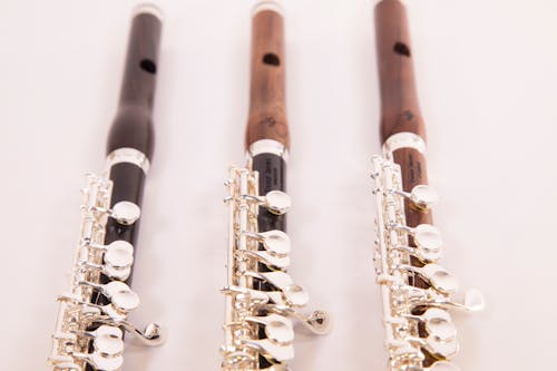 Close-Up Photograph of Piccolo Flutes on a White Surface