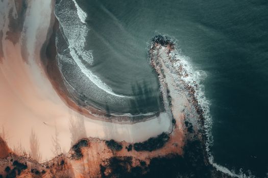 Dramatic aerial view of Terengganu's coastline with crashing waves and sandy beaches.