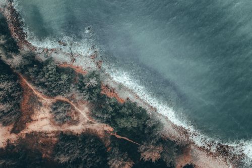 Free A stunning aerial view of Terengganu's coastline highlighting lush greenery and crashing ocean waves. Stock Photo