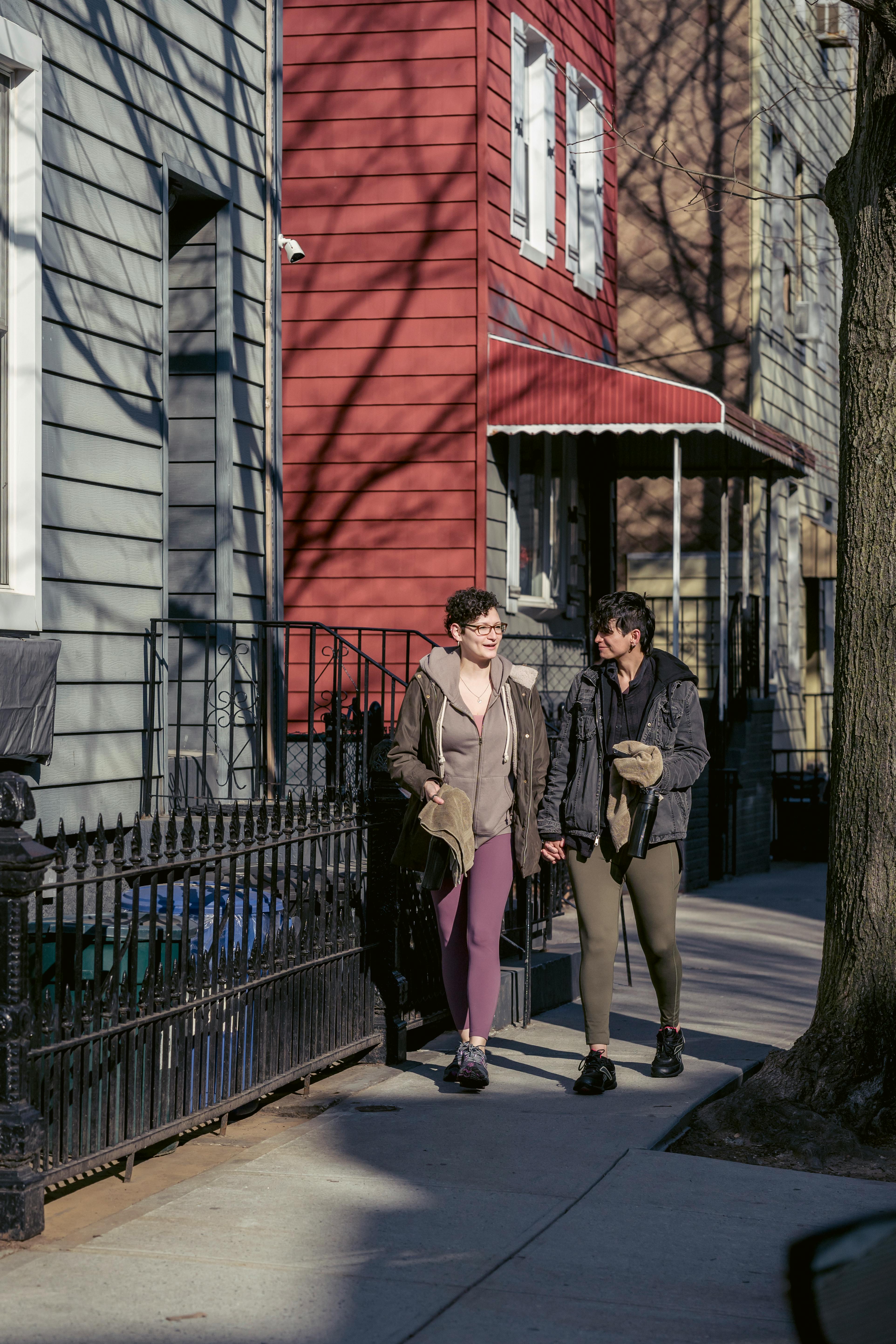 positive lesbian couple walking on autumn street together