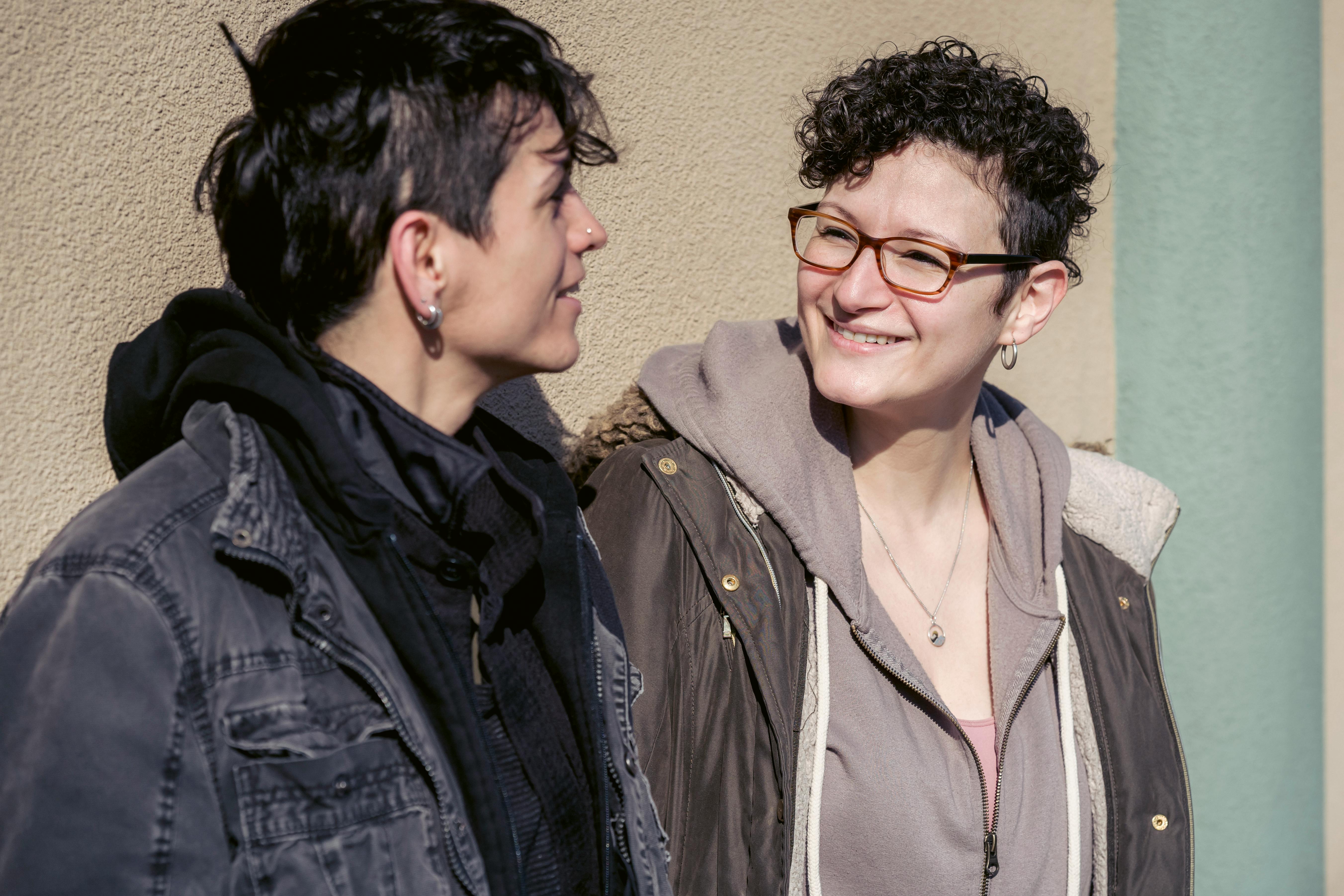 happy lesbian couple having conversation on sunny autumn street