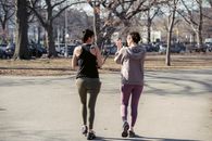 Fit sportswomen walking in sunny autumn park