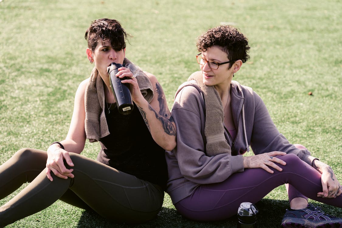 Free Couple of sportswomen relaxing on grass Stock Photo