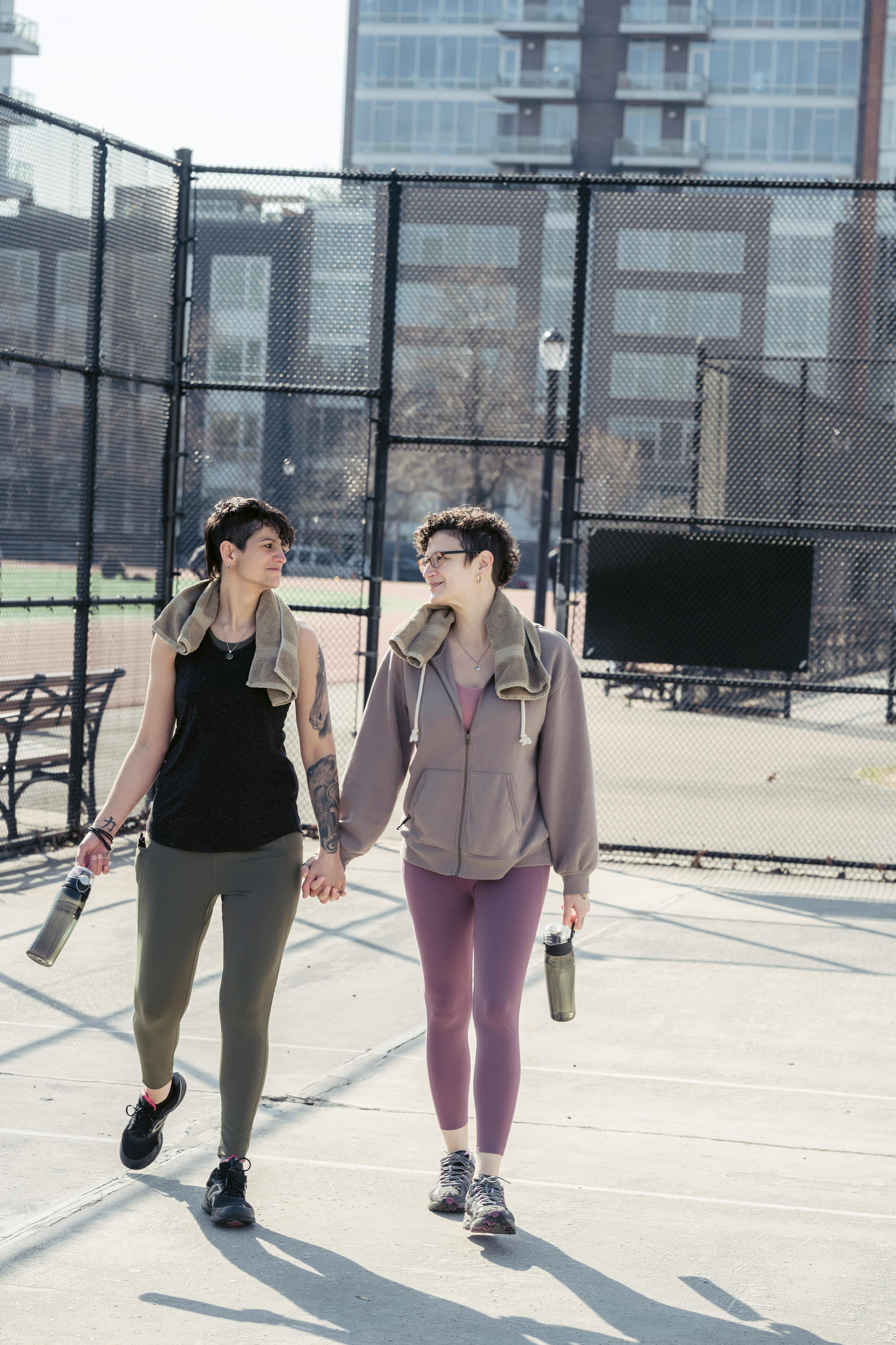 lesbian couple looking at each other and holding hands outdoors