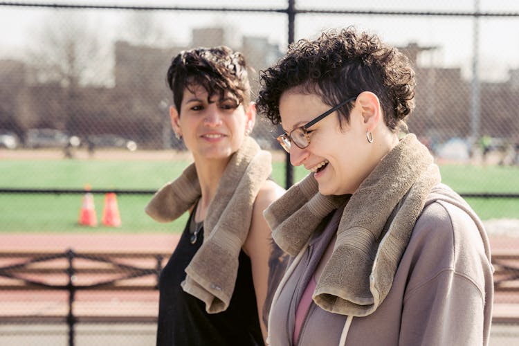 Delighted Active Ladies Walking On Stadium After Outdoor Workout