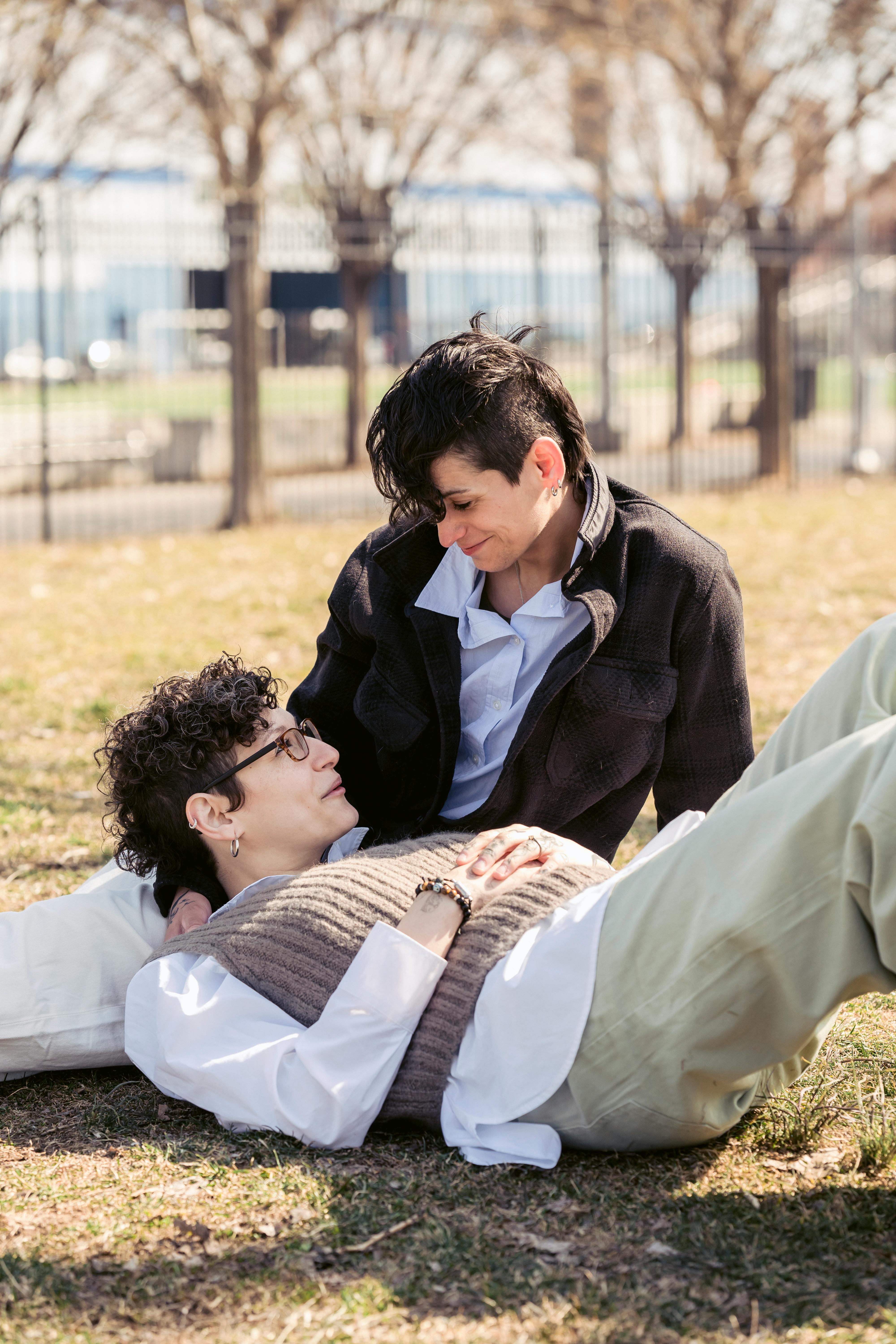 loving lesbians lying on lawn in city park