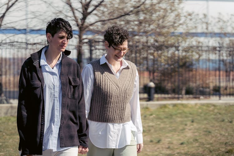 Positive Androgynous Friends Walking On Urban Street