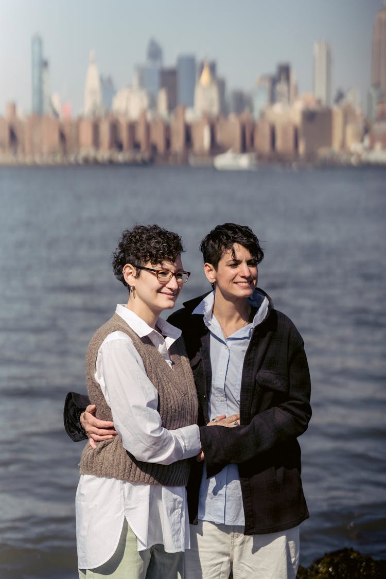 Cheerful Women Embracing On River Embankment