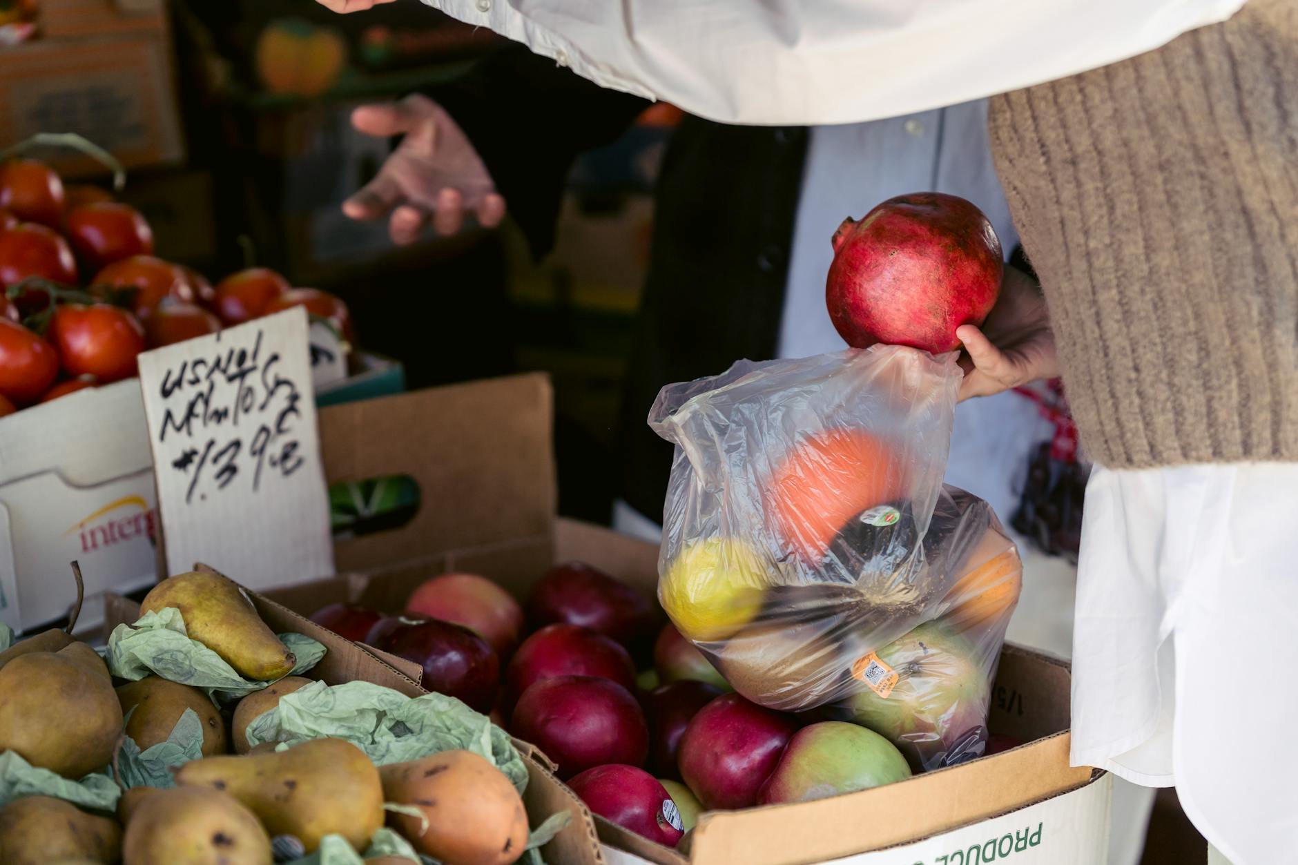 Crop woman choosing assorted healthy fruits street market