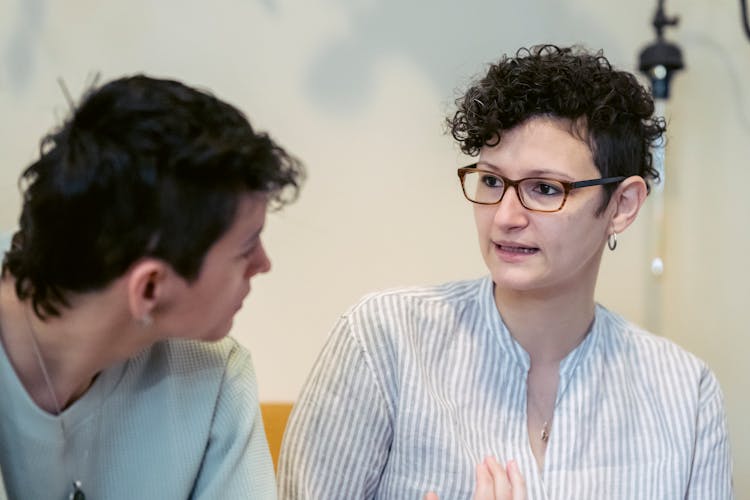 Young Woman Explaining Problems To Focused Female Friend