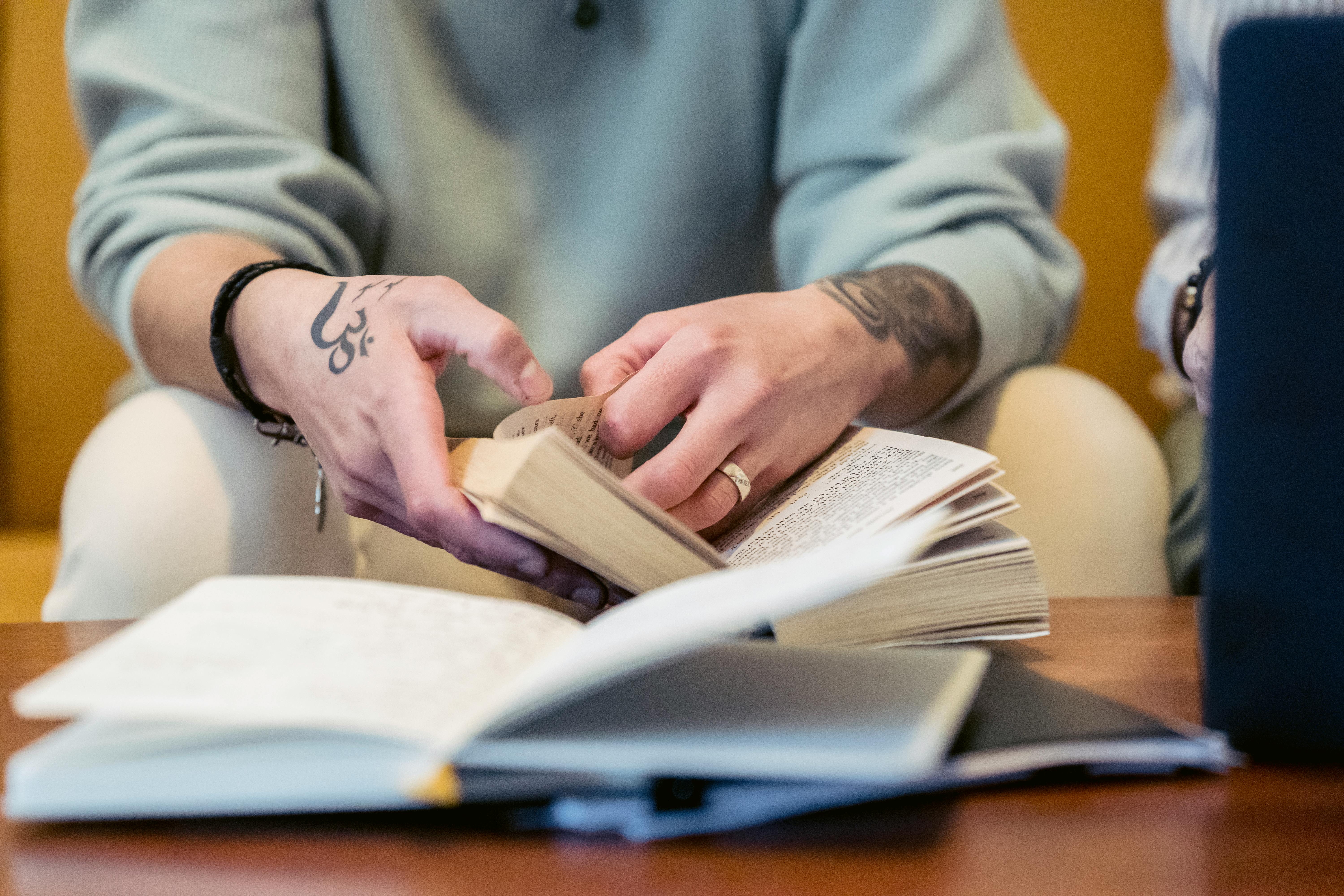 anonymous person reading novel on couch at home