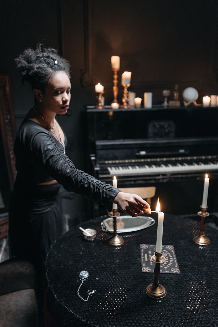 A Woman In Black Long Sleeve Dress Holding A Matchstick