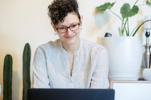 Free Excited young woman working remotely on netbook at home Stock Photo