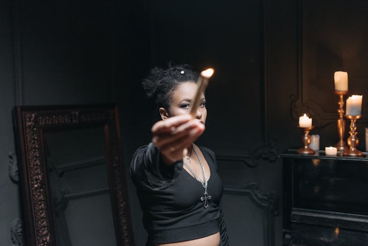 Woman Holding A Burning Candle Reached Out Towards The Camera 