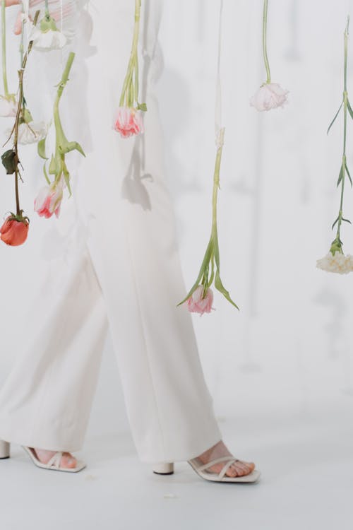 Photo of a Person Walking Near Flowers