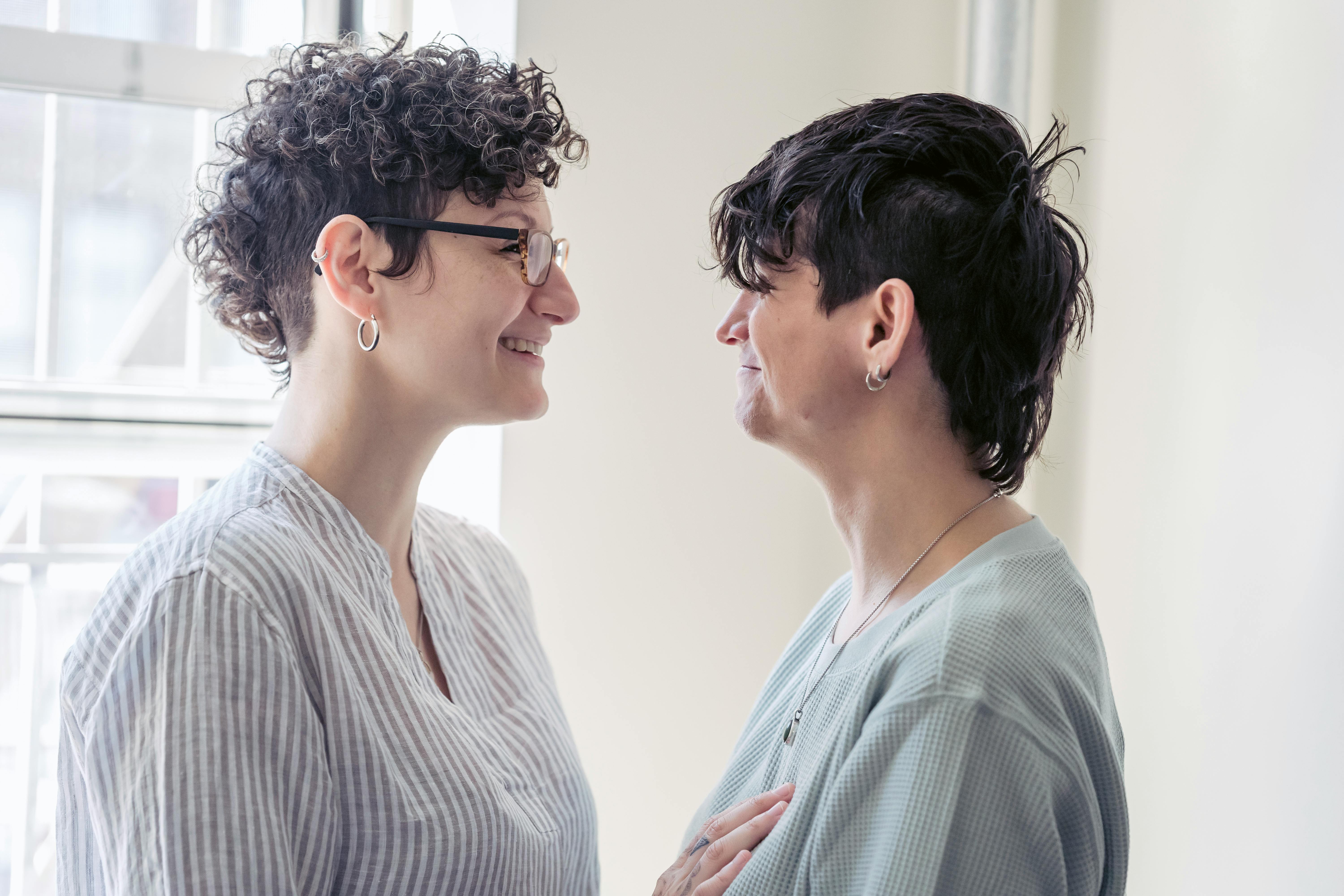 cheerful homosexual women speaking in house room