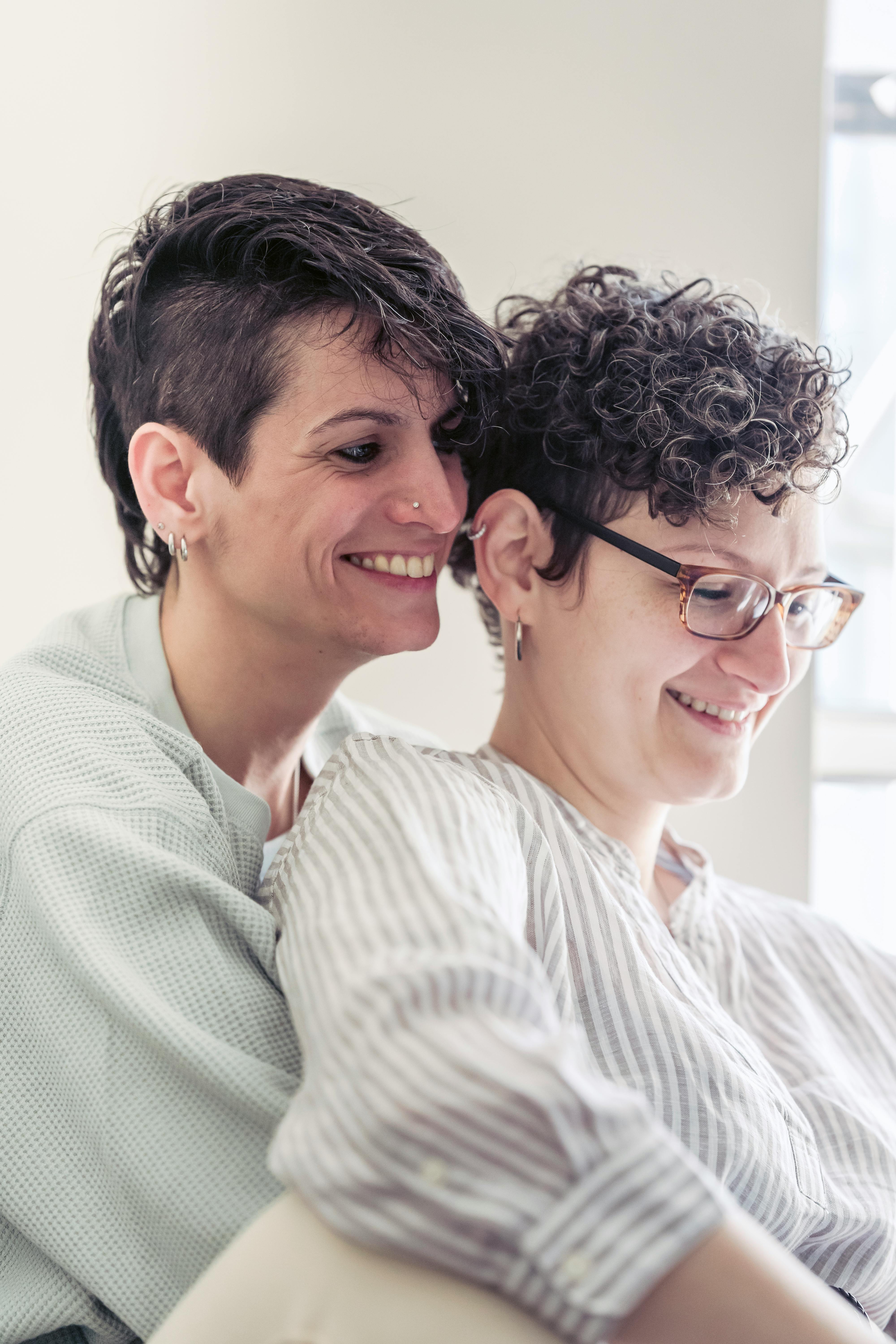 cheerful woman embracing homosexual girlfriend at home