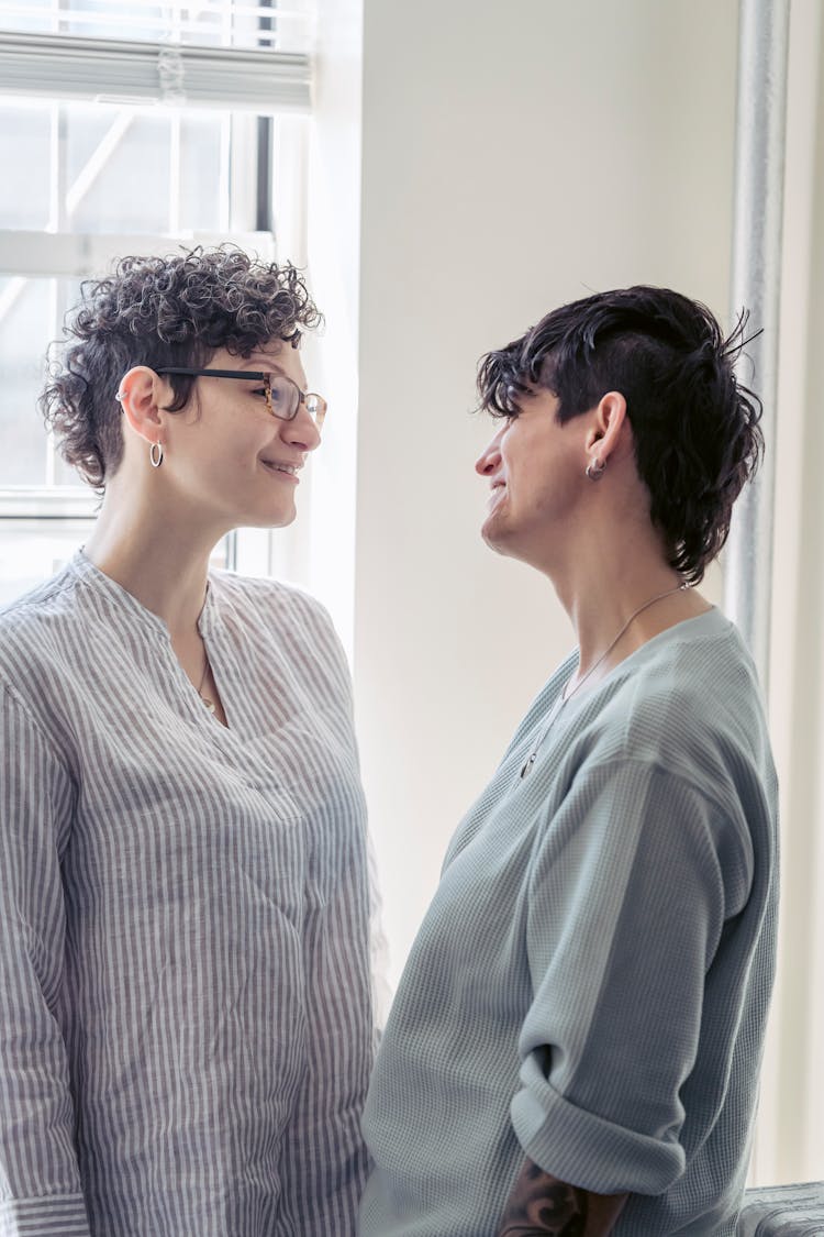 Smiling Lesbian Couple Talking In House Room