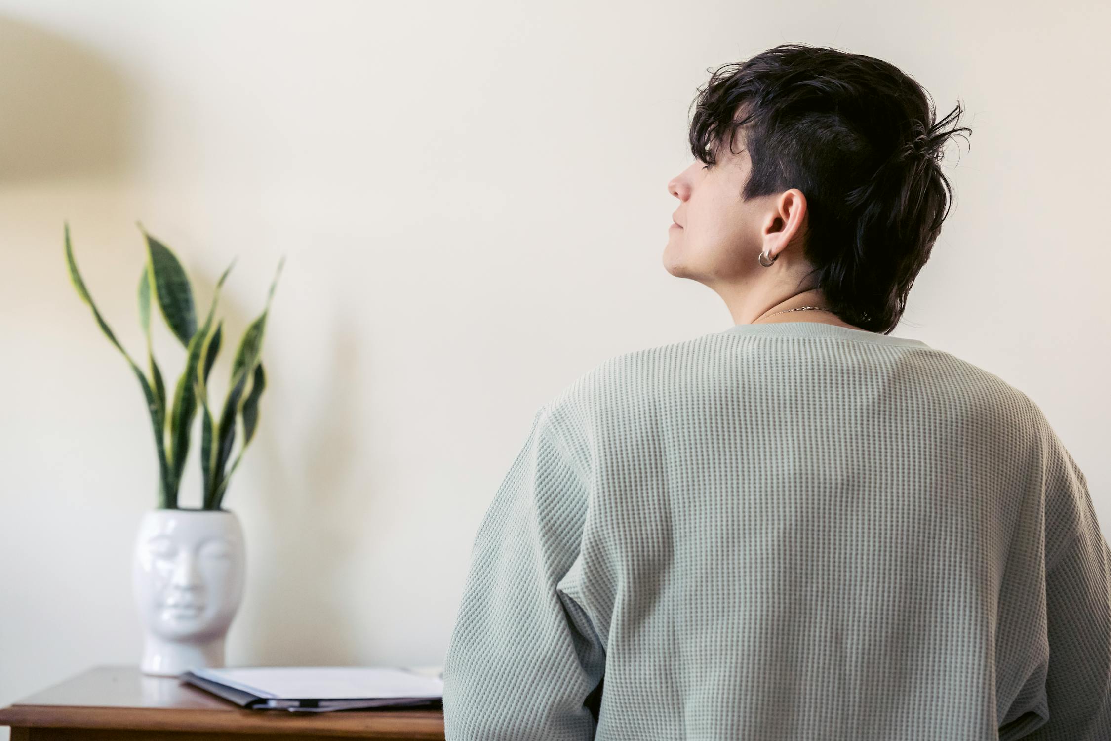 Woman at table with snake plant in pot