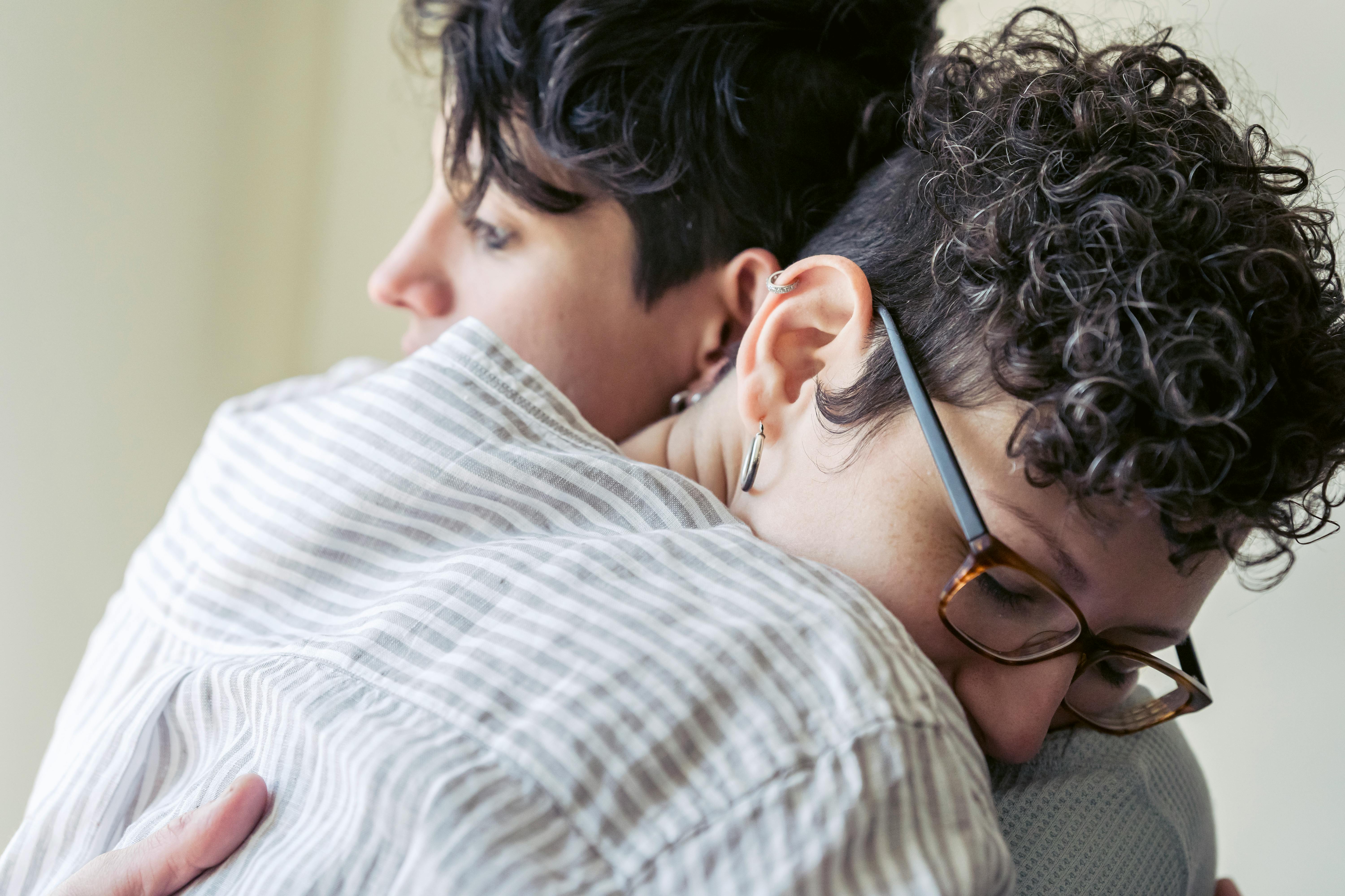 crop lesbian couple embracing gently at home