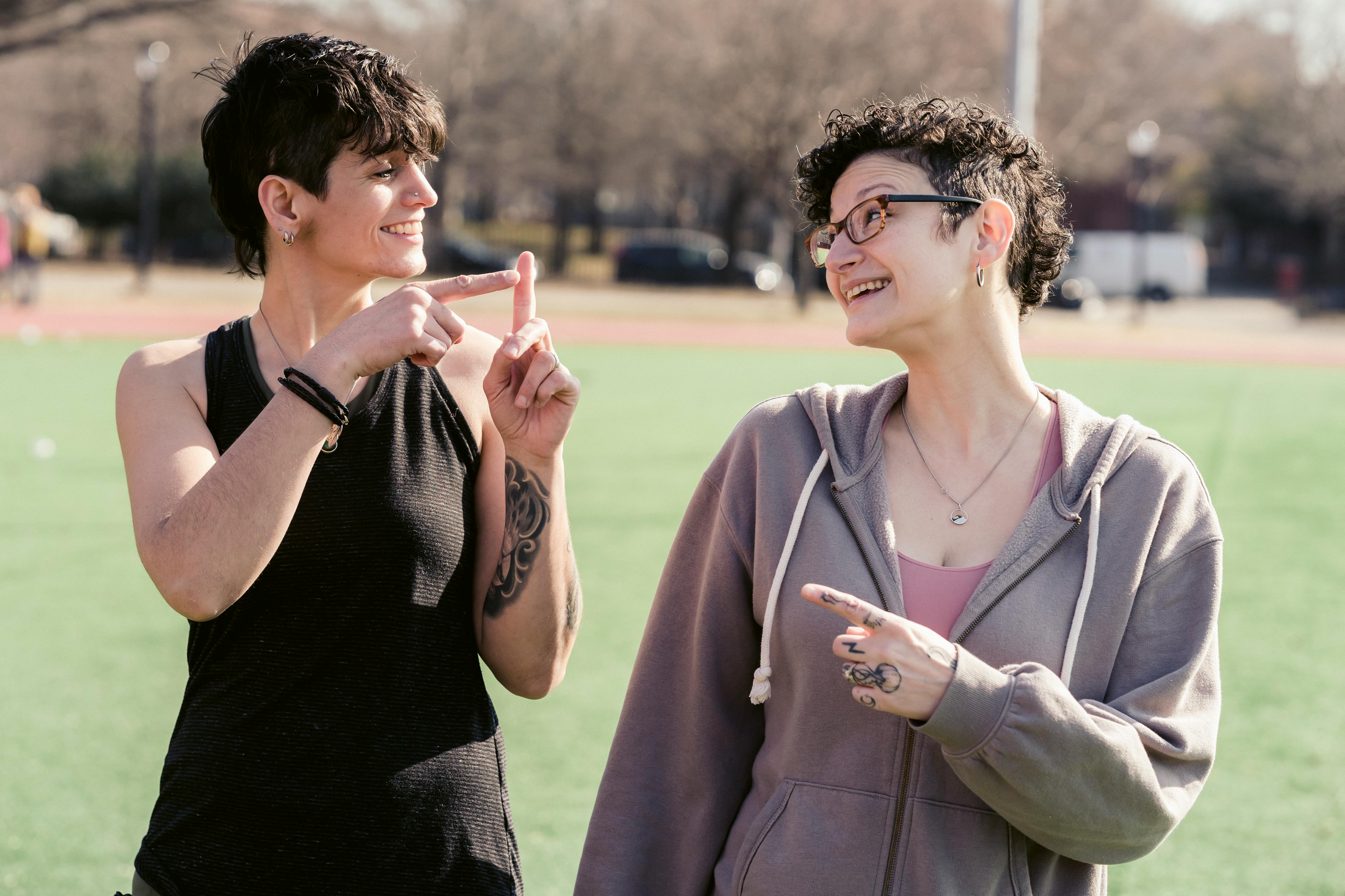 cheerful women showing gesture on street