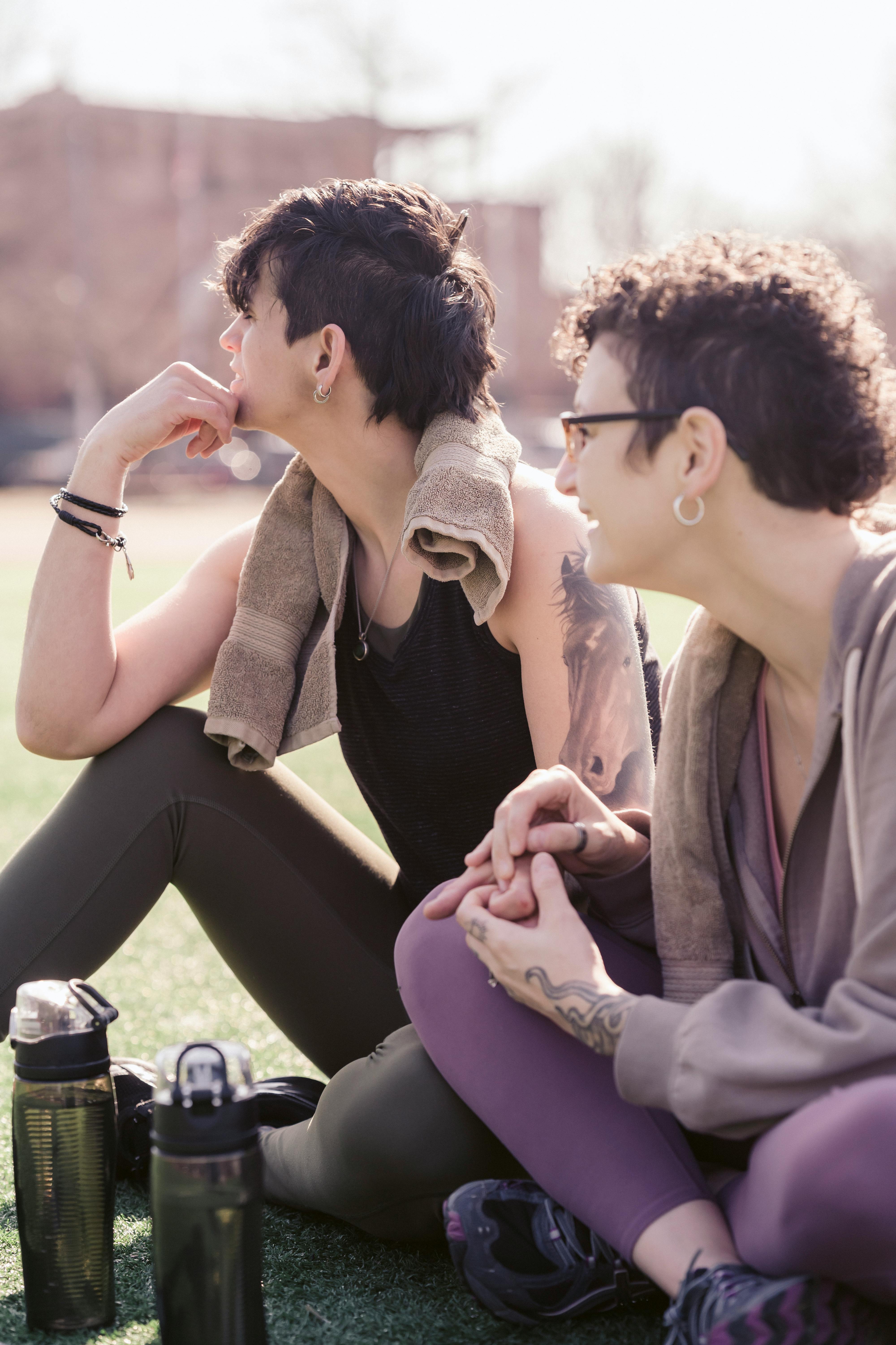 Positive lesbians in sportswear on lawn · Free Stock Photo