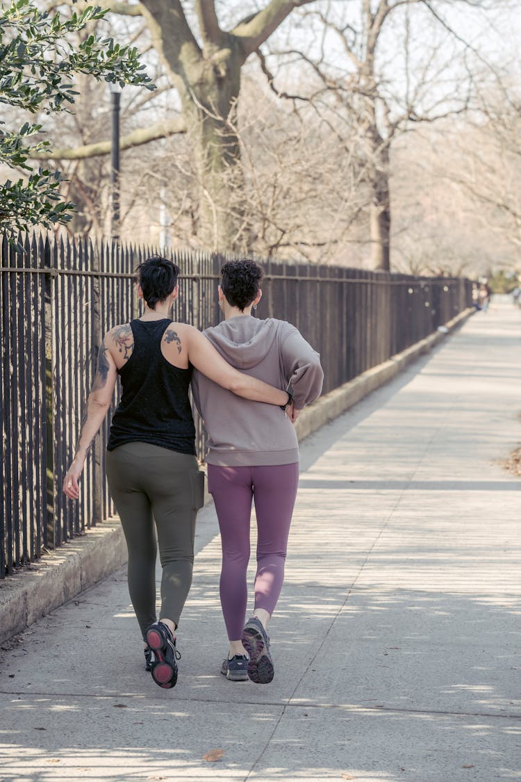 Unrecognizable Homosexual Couple Walking On Walkway