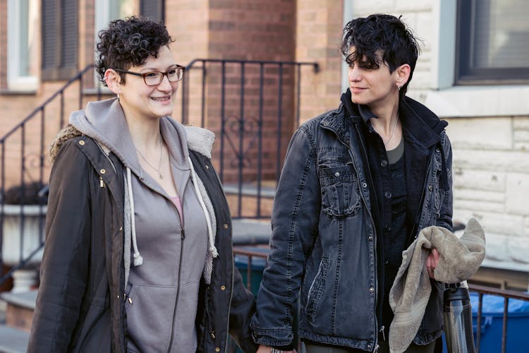 Positive Homosexual Couple Walking Along Building