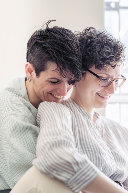 Free A happy LGBTQ couple shares an intimate moment, enjoying each other's company indoors in soft natural light. Stock Photo