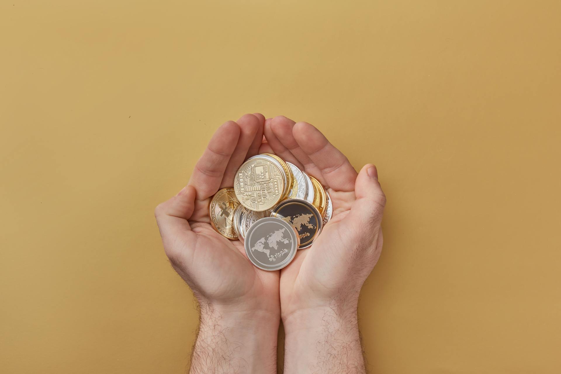 Person Holding Gold and Silver Round Coins