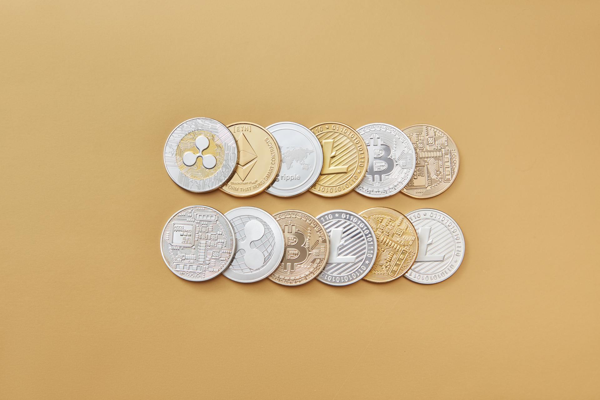 A collection of digital cryptocurrency coins, including Bitcoin and Ethereum, arranged on a stylish gold backdrop.