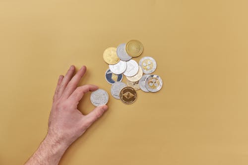 Hand and Gold and Silver Round Coins