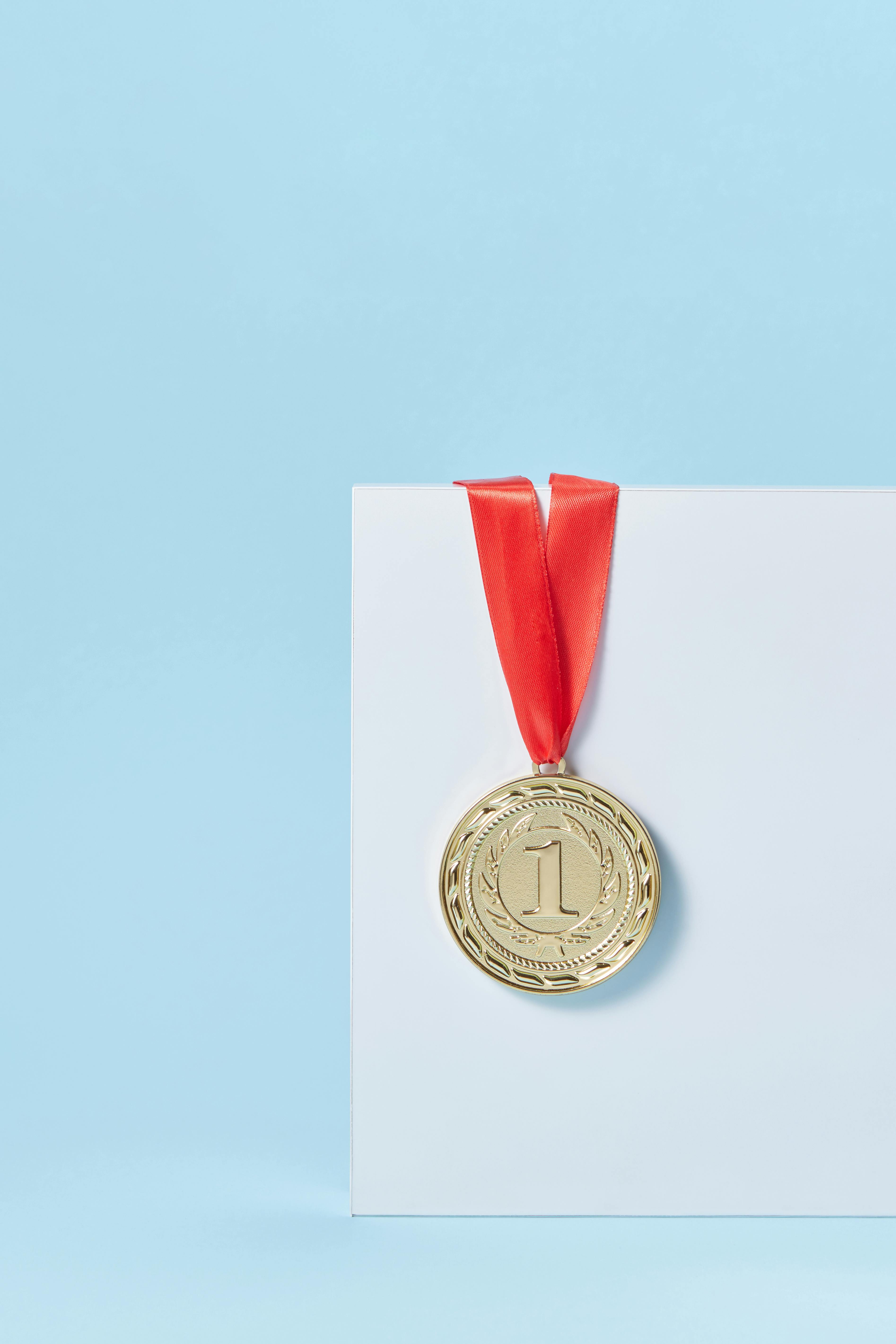 a medal with red lanyard on white paper