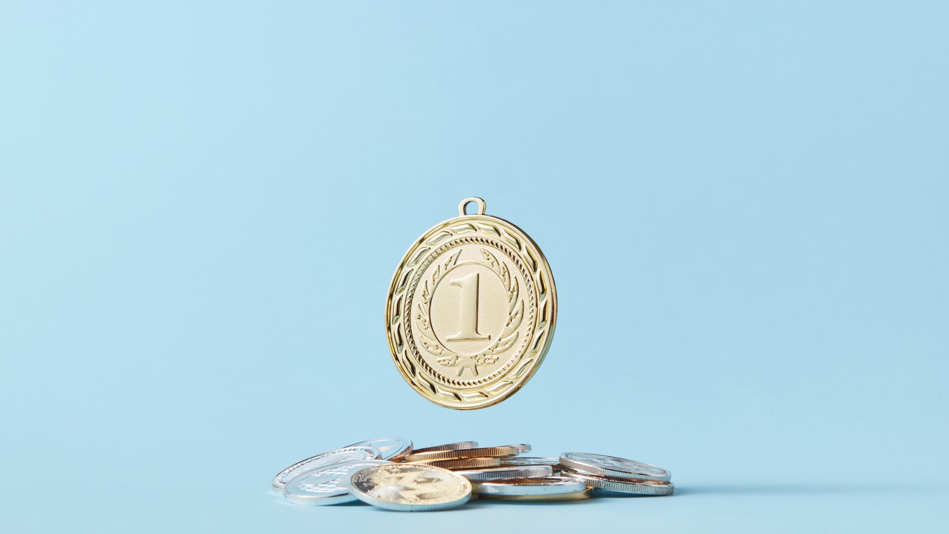 Maximising Benefits Tips: Unlocking the Full Potential A gold medal and pile of coins on a light blue background representing achievement and savings — maximising benefits tips