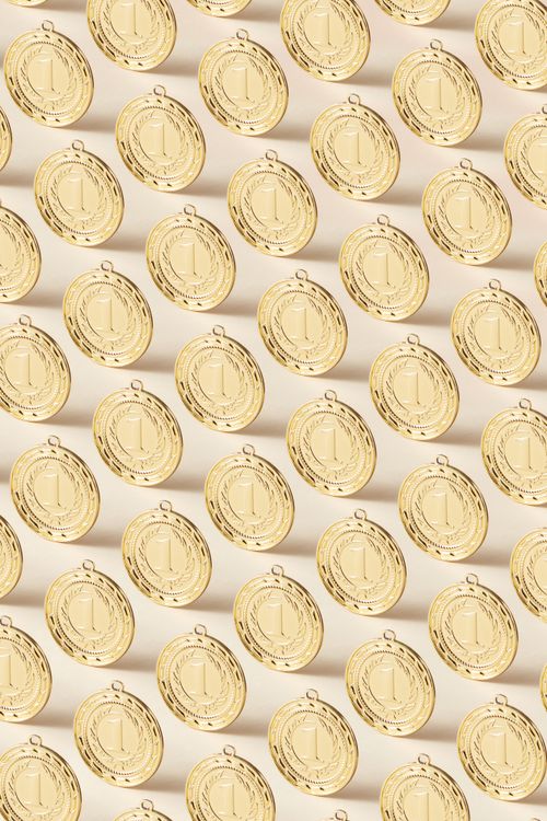 Free Repeating pattern of gold medals with sailing motif in a studio setup. Stock Photo