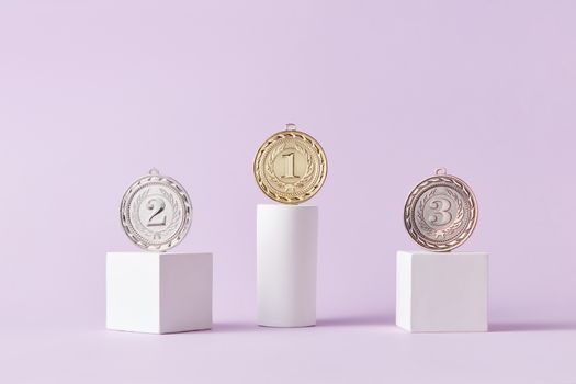 Medals on a podium against a soft pastel background, ideal for awards themes.