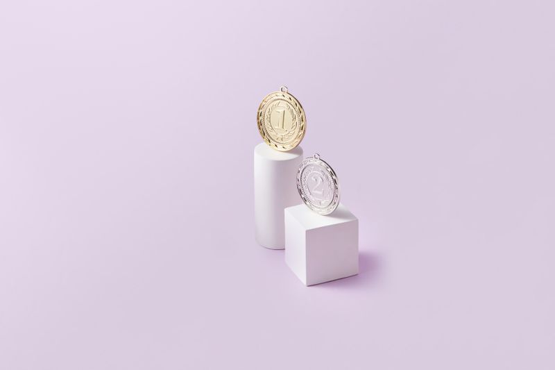 Gold and silver medals on display podiums — corporate recognition awards collection